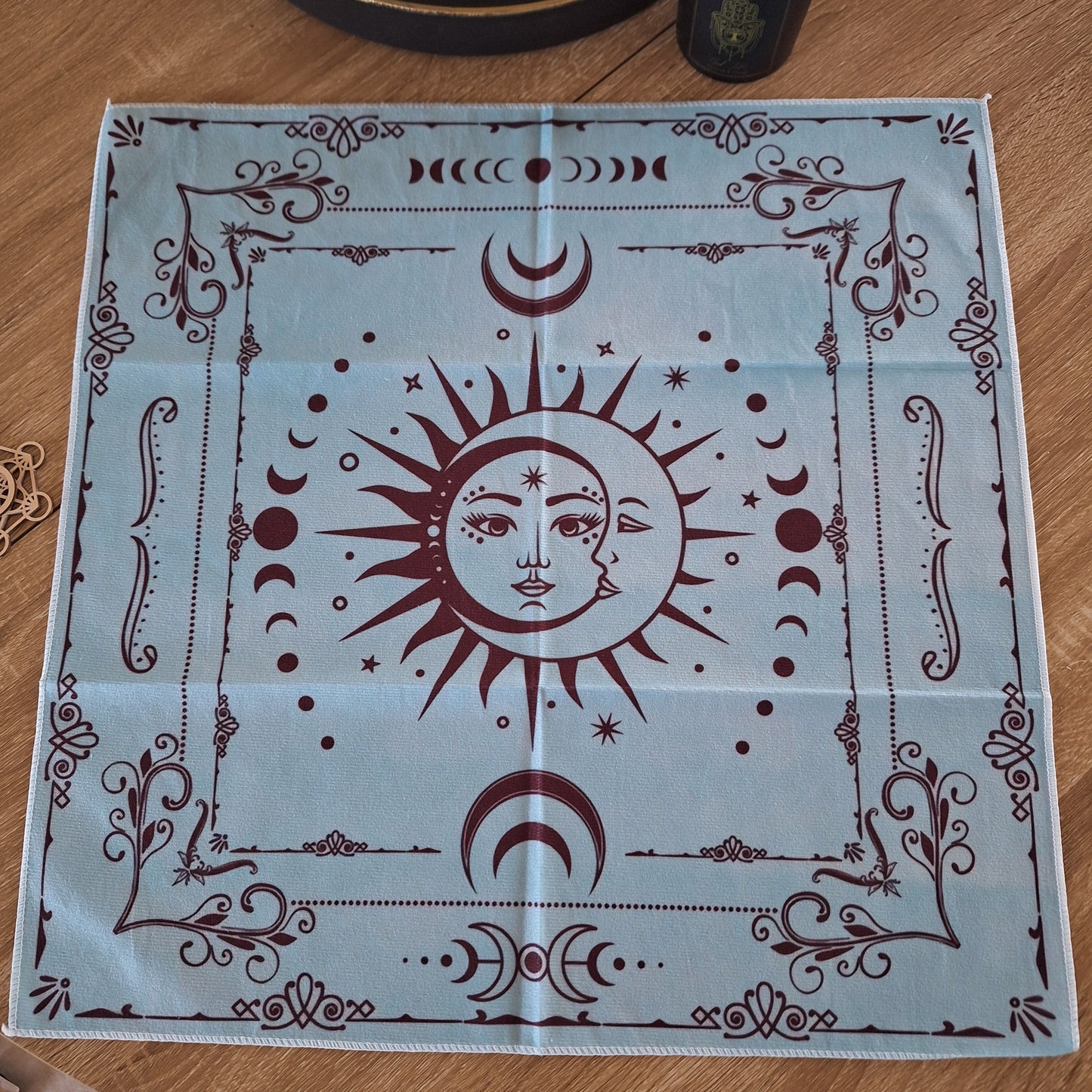 Tapis mystique bleu et chocolat 49x49cm avec motifs ésotériques, phases de la lune et symbole soleil-lune au centre. Idéal pour divination.